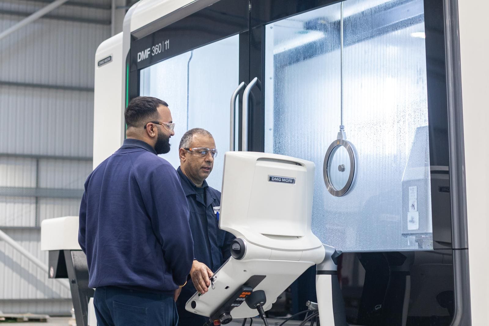 Accura Engineering apprentice and mentor operating a DMG Mori 5-axis machining centre at the Centre of Excellence in Willenhall.